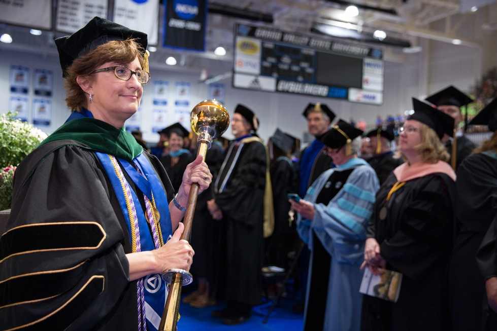 A woman holds the mace at a convocation ceremony